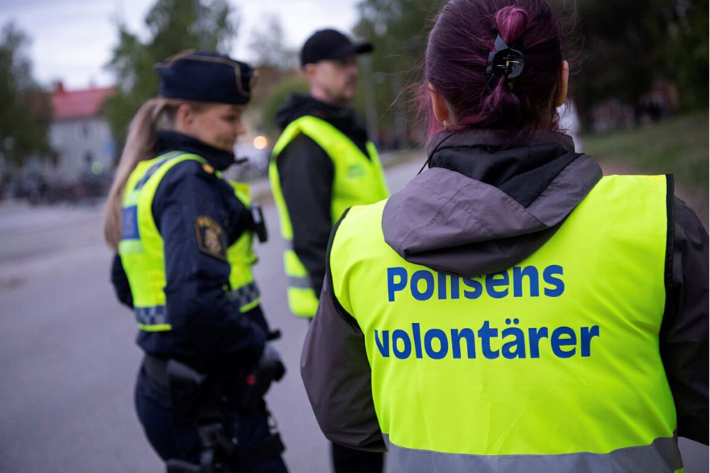 Kvinnlig polis och volontärer utomhus