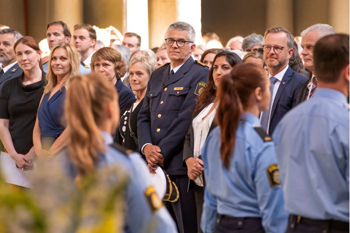 Rikspolischefen omgiven av polisstudenter vid polisexamen.