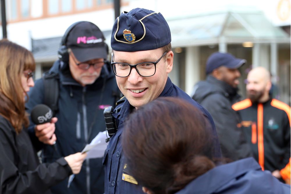 Polis i uniform pratar med en medborgare.