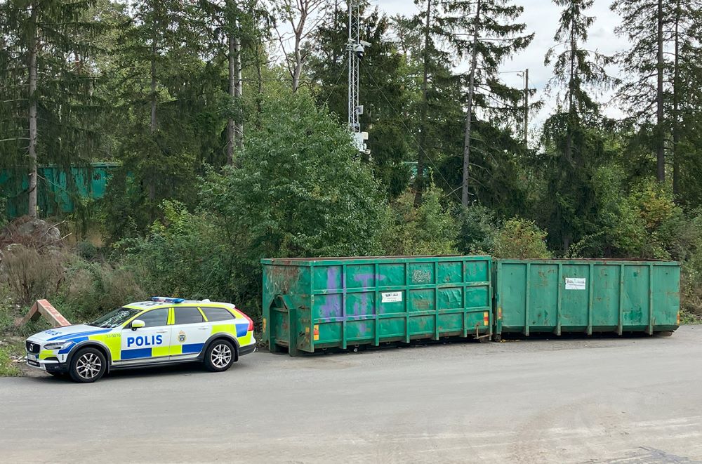 En polisbil vid en återvinningsstation