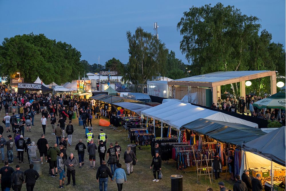 Bild över ett festivalområde med människor och två poliser