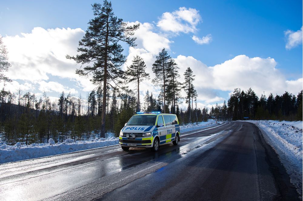 Polisbil parkerad i ett vinterlandskap