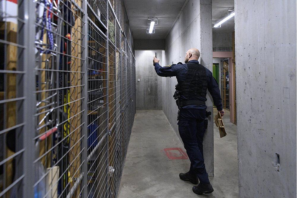 En polis undersöker ett stölddrabbat källarförråd.