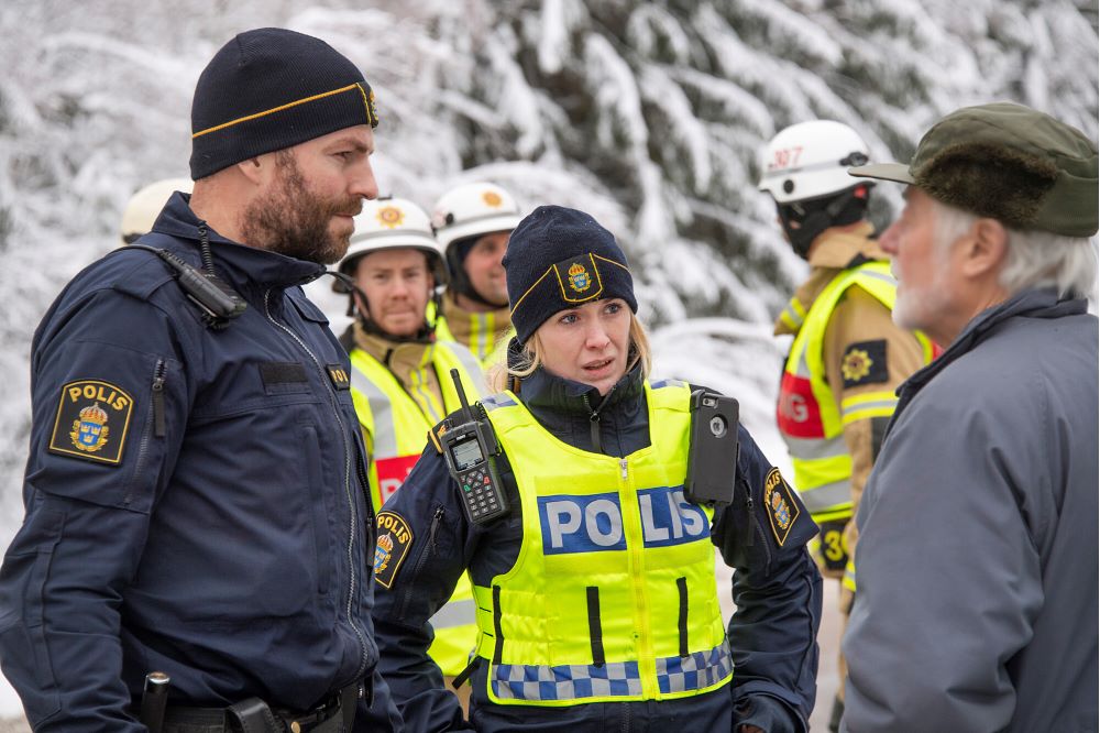 Två poliser samtal med en allmänhet vid en olycksplats