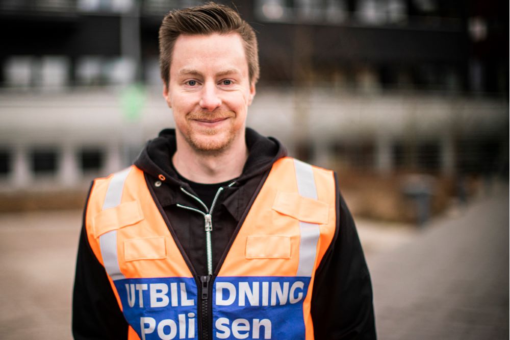 Ung man med texten "Utbildning polis" på magen. Foto.