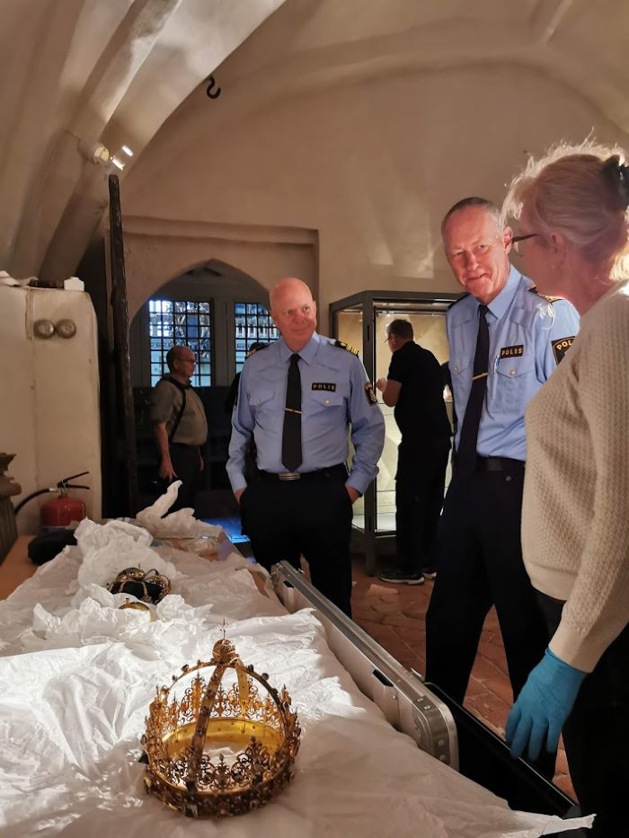 Anders Wretling, Christer Nilsson och Anna Marie Christensson står framför ett bord där regalierna är upplagda. Foto.