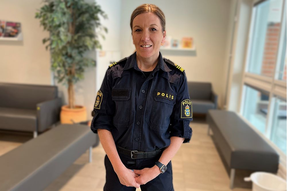 Lisa Nilsson står i polisens reception iklädd polisuniform och tittar in i kameran.