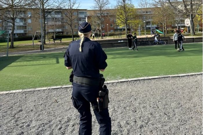 Kvinnlig polis ute i bostadsområde.