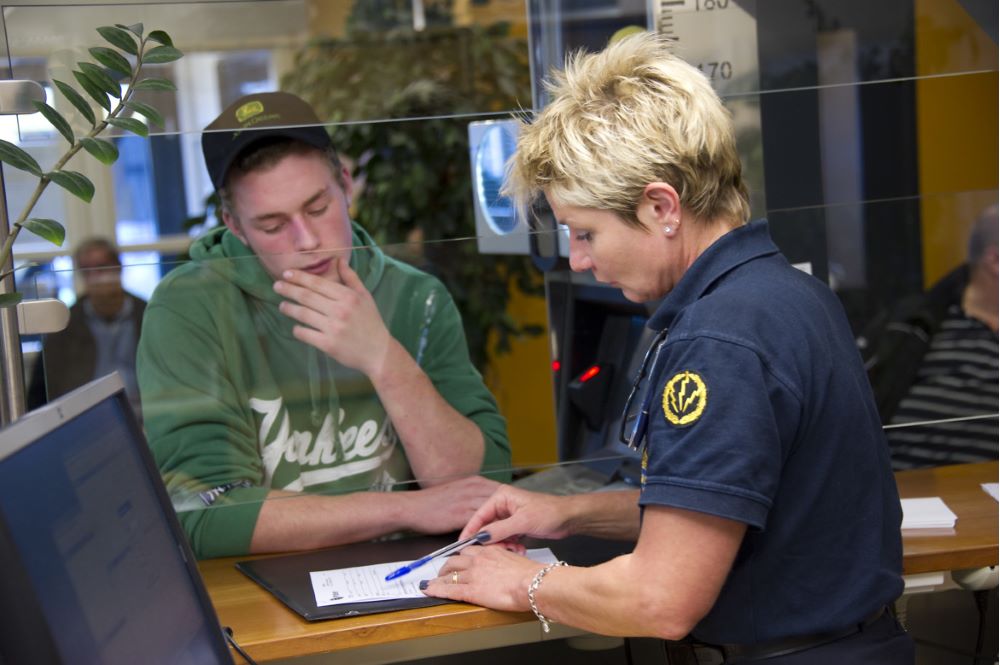 Policeman helping a man applying for a passport