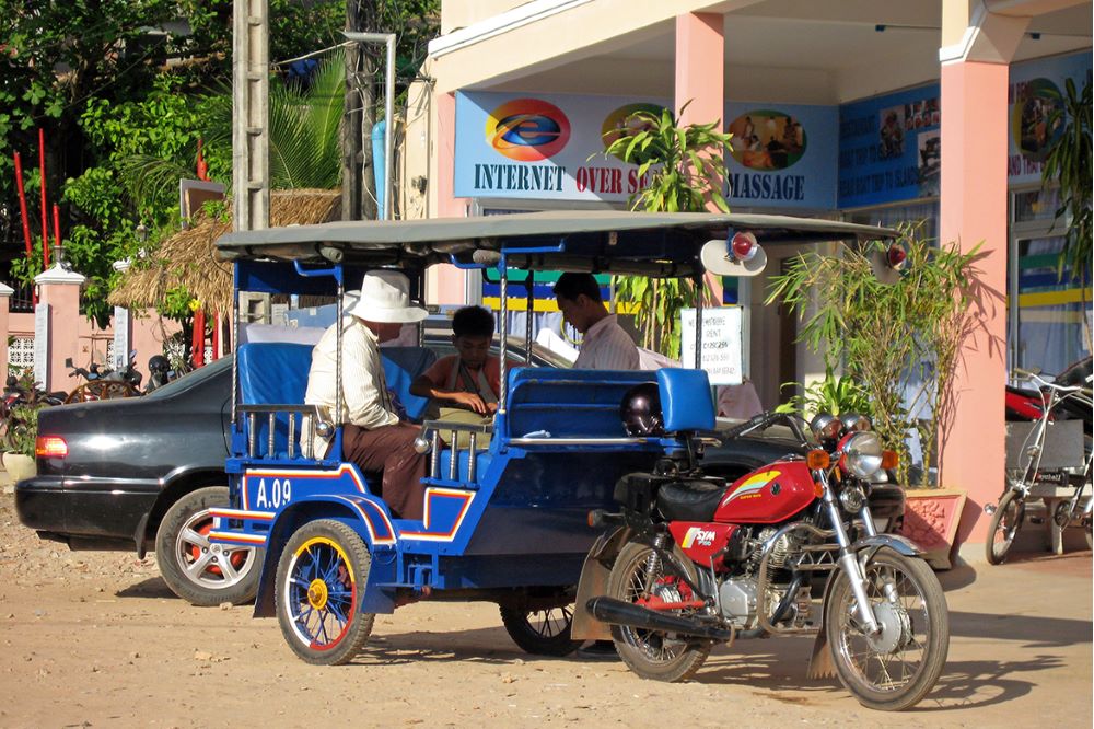 En tuk-tuk utomlands med ett barn och två män i.