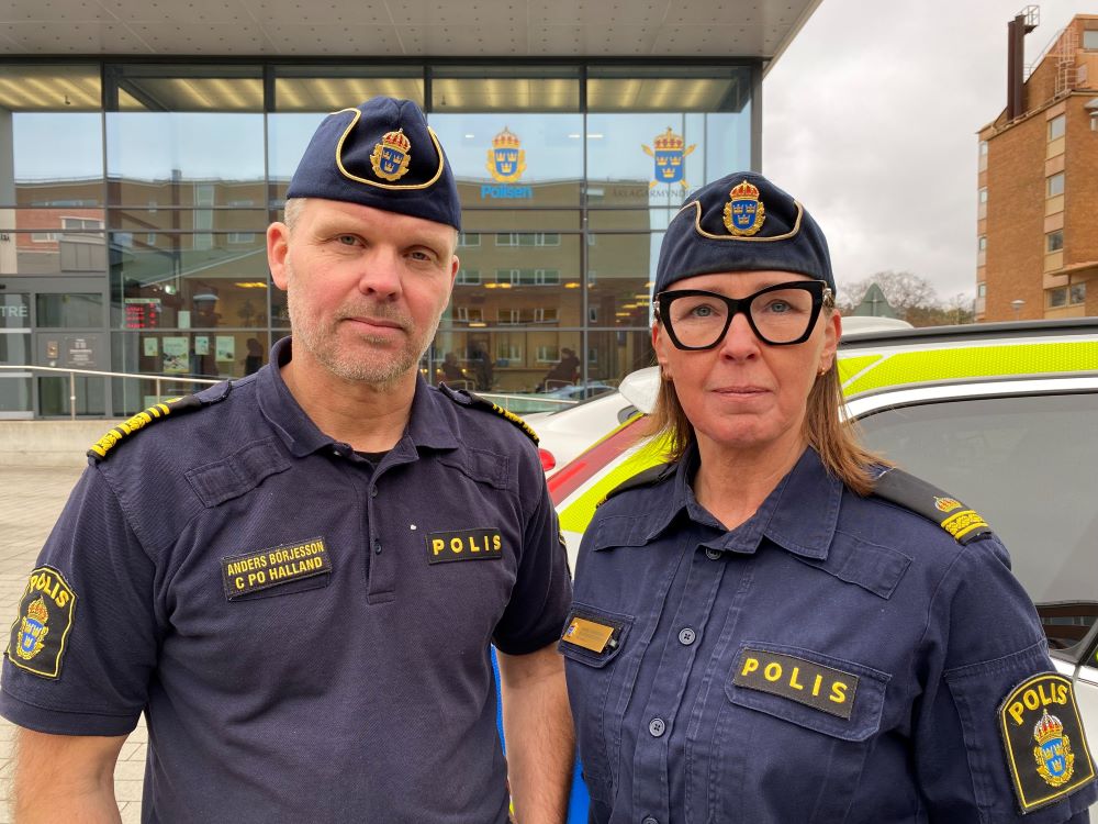 Två poliser som står vid ett polishus